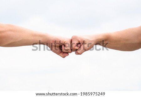 Fist Bump. Clash of two fists. Concept of confrontation, competition. Gesture of giving respect or approval. Teamwork and friendship. Partnership concept. Man giving fist bump. Bumping fists together Foto stock © 