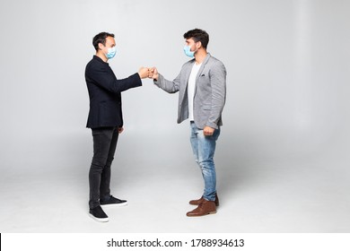 Fist Bump Greeting. Two People In Suits Greet Each Other In A Meeting. They Give Up The Untraditional Handshake Isolated On A White Background.