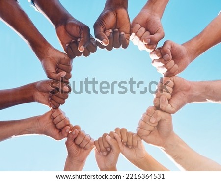 Fist hands, circle and diversity support human rights people, protest group and freedom of racism on blue sky background. Below solidarity, partnership and motivation of goals, trust or world justice
