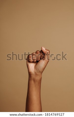 Fist held tightly against brown background. Close fist symbolizing the black lives matter movement.