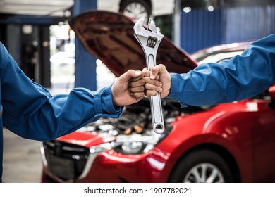 Fist and mechanics hand with tool of two auto mechanic doing car service and maintenance. Repair service concept. Car repair and maintenance. Car mechanic working at automotive service center. - Powered by Shutterstock