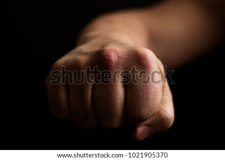 Fist on a black background, a punch in the face