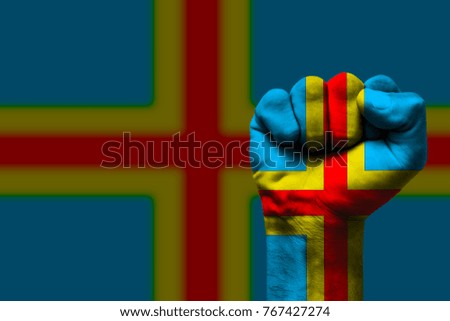 Fist painted in colors of Aland islands flag, fist flag, country of Aland islands