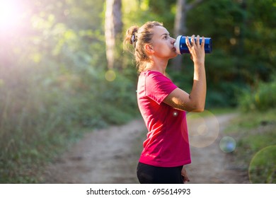 Fit and active attractive young woman drinking water after training outdoor - Shutterstock ID 695614993
