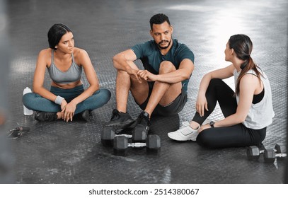 Fit, active and healthy gym team talking, bonding and planning workout, training and exercise in wellness center. Sporty, athletic or strong man and women on break from intense dumbbell weightlifting - Powered by Shutterstock