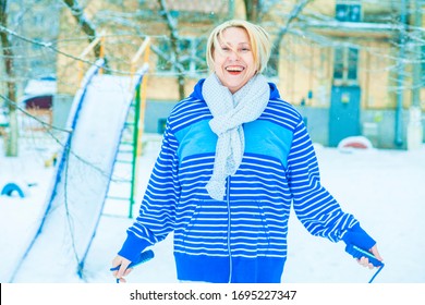 Fit Active Old Blond Woman Performing Training And Doing Her Warming Up Exercise With Jumping Rope Outdoors Snowy Winter