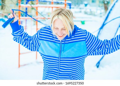 Fit Active Old Blond Woman Performing Training And Doing Her Warming Up Exercise With Jumping Rope Outdoors Snowy Winter