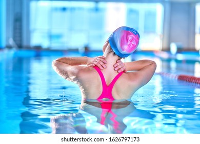 Fit active woman doing water gymnastics and aerobics in a sports swimming pool in leisure center. Pool workout, treatment and prevention of back and neck disease, healthy back