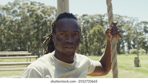 Fit african american male soldier with deadlocks climbing down rope on army obstacle course. healthy active lifestyle, cross training outdoors at boot camp. - Powered by Shutterstock