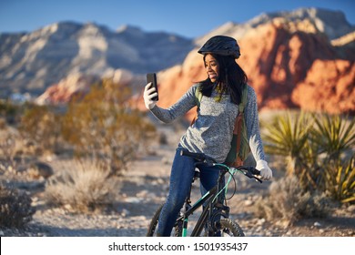 Fit African American Woman Taking A Break From Riding Bike To Use Smartphone For Selfie