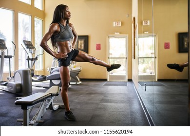 fit african american woman working out and stretching in gym