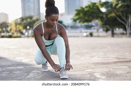 Fit African Girl Ties Her Shoes During Sport Running Workout In The City