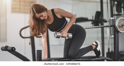 Fit Asian Athletic Woman Lifting Weights Inside Home Gym, Muscular Building Concept