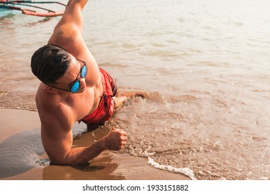 A Fit Asian Man Does Side Planks At The Beach. Core Oblique Workout Or Calisthenics Outdoors.