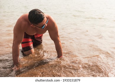 A Fit Asian Man Prepares To Do Pushups At The Beach. Chest Workout Or Calisthenics Outdoors.