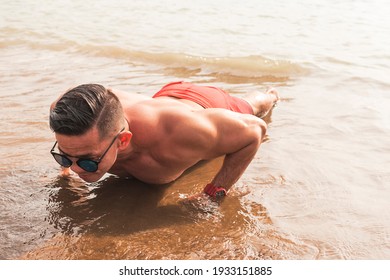 A Fit Asian Man Wearing Shades Does Pushups At The Beach. Chest Workout Or Calisthenics Outdoors.