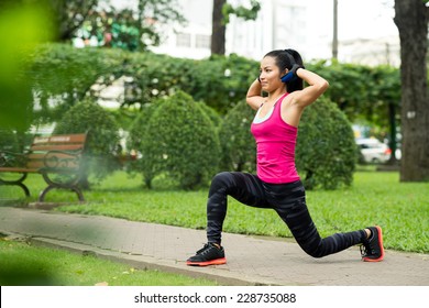 Fit Asian Woman Doing Lunge Exercise In Park 