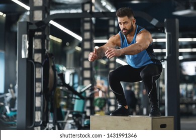 Fit athlete doing box jump exercise at gym, practicing functional training, empty space