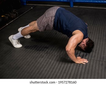 A Fit And Athletic Asian Man Does Pike Push-ups At The Gym. HIIT Or Calisthenics Workout