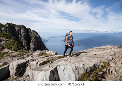 Fit Athletic Latin American Male Hiker Is Walking Up The Mountain Overlooking The Beautiful Landscape. Picture Taken On The Way Up To The Lions Peaks, North Of Vancouver, British Columbia, Canada.