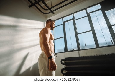 A Fit and Athletic Man is Posing in a Bright and Modern Industrial Gym Environment