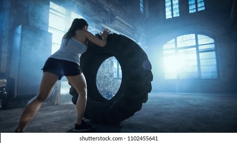 Fit Athletic Woman Lifts Tire as Part of Her Cross Fitness/ Bodybuilding Training. - Powered by Shutterstock