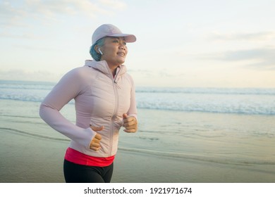 Fit And Attractive Mature Woman With Grey Hair Doing Beach Workout On Her 50s Running On The Beach Happy And Free In Senior Fitness Selfcare And Wellness Concept