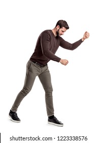 A fit bearded young man in casual clothes tries to hit or make something as if holding an invisible tool. Manual work. Hard labor. Difficult work. - Shutterstock ID 1223338576