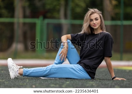 Fit blonde blueeyed woman in oversized clothes posing outdoor