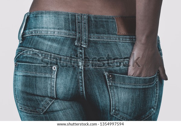 「白い背景に黒いミックスレースの女性のジーンズにフィット。」の写真素材（今すぐ編集） 1354997594
