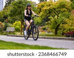 Fit Caucasian Woman riding an Electric Bicycle on a trail in Stanley Park, Downtown Vancouver, British Columbia, Canada.