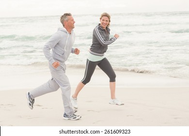 Fit Couple Jogging Together At The Beach