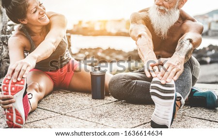 Fit couple making stretching before running workout - Joggers training outdoor at sunset together - Main focus on woman face - Fitness, sport, wellness, workout, gym and healthy lifestyle concept