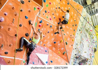 Fit couple rock climbing indoors at the gym - Powered by Shutterstock