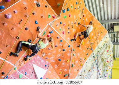 Fit Couple Rock Climbing Indoors At The Gym