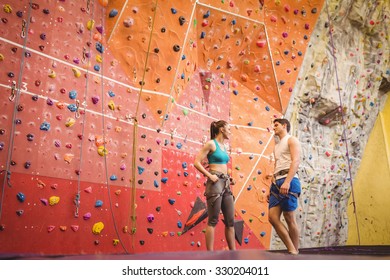 Fit Couple At The Rock Climbing Wall At The Gym