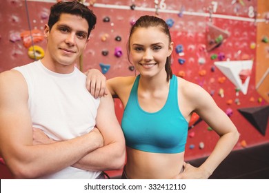 Fit Couple At The Rock Climbing Wall At The Gym