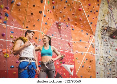 Fit Couple At The Rock Climbing Wall At The Gym