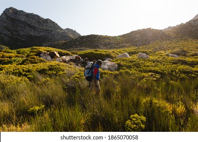 A fit, disabled mixed race male athlete with prosthetic leg, enjoying his time on a trip to the mountains, hiking, walking through grass. Active lifestyle with disability. - Powered by Shutterstock