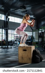 Fit female athlete jumping box at body training in dark gym. Fitness woman jump exercise in sport club. Strong girl cardio workout. Fit trainer weight loss exercise fat burning - Shutterstock ID 2171112841