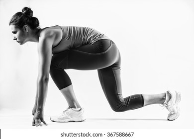 Fit Female Athlete Ready To Run Over Grey Background. Female Fitness Model Preparing For A Sprint.