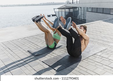 Fit fitness woman and man doing fitness exercises outdoor at city background. the best abdominal muscle press in the world. Female and male sports models exercising in summer at morning. - Powered by Shutterstock