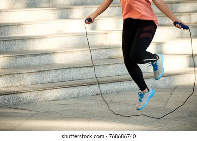 Fit girl jumping with skipping rope outdoors - Shutterstock ID 768686740