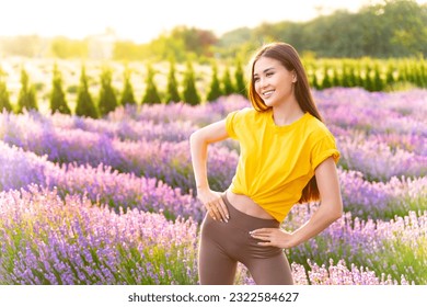 Fit girl wearing yellow t shirt posing in lavender field enjoying perfect summer morning. - Powered by Shutterstock