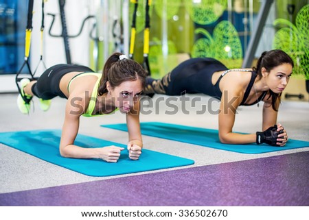 Fit girls in gym doing plank exercise for back spine and posture Concept pilates fitness sport
