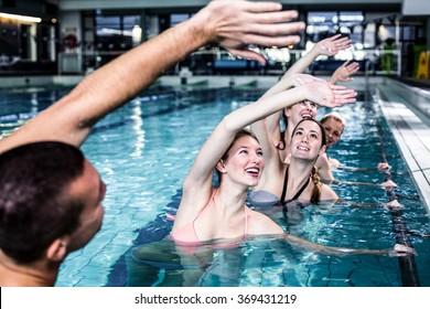 Fit group doing aerobical excercises in swimming pool