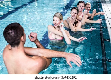 Fit group doing aerobical excercises in swimming pool
