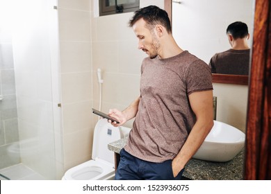 Fit Handsome Young Man Hiding In Bathroom When Texting To Another Woman