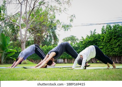 Fit Happy People Working Out Outdoor. Family Asian Parent And Child Daughter Exercising Together On A Yoga Mat At Home Garden. Family Outdoors. Exercise At The Home Concept And New Normal.

