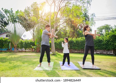 Fit Happy People Working Out Outdoor. Family Asian Parent And Child Daughter Exercising Together On A Yoga Mat At Home Garden. Family Outdoors. Exercise At The Home Concept And New Normal.

